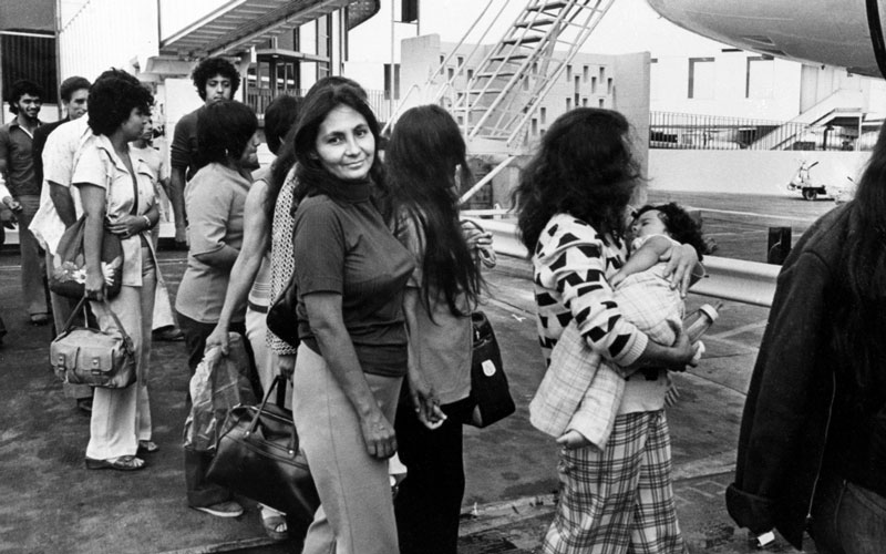 Illegal Mexican immigrants, among them a woman carrying a baby, are boarding a plane in Los Angeles, Calif., as they are being deported back to their native Mexico, July 27, 1976. (AP Photo)